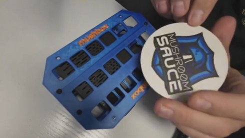 A 3D-printed blue Mushbox plate and Mushroom Sauce sticker, from ALLDAYNYC's TikTok